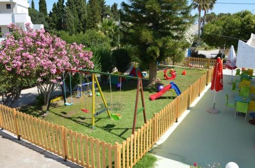 a playground in a backyard with a fence at Kosinmyheart Apartment 11 & Studio10 in Kos Town