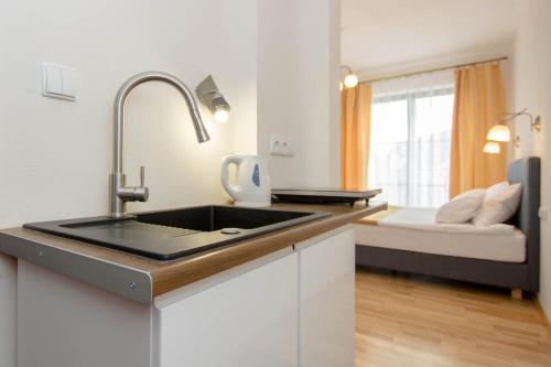a kitchen with a sink and a bed in a room at Porto in Karwia