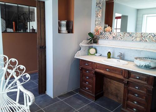 a bathroom with a sink and a mirror at Le Lodge de Loge & Broc in La Possonnière