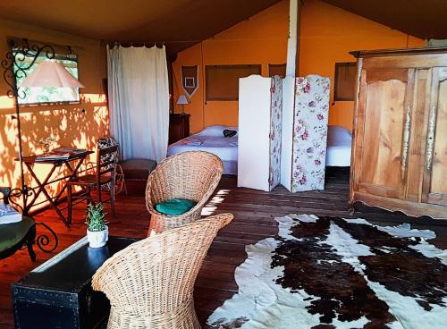 a living room with two chairs and a refrigerator at Le Lodge de Loge & Broc in La Possonnière