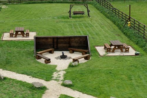 a park with benches and tables in a field at Avalanche Plaiul Foii in Zărneşti