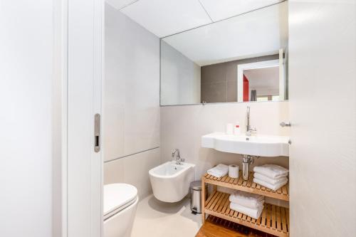 a bathroom with a sink and a toilet and a mirror at Quercus Appartements contactless check-in in Patergassen