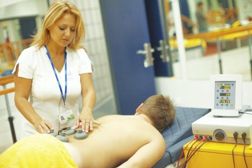 a woman giving a man a massage at Medical and Spa Centre Merkur in Vrnjačka Banja