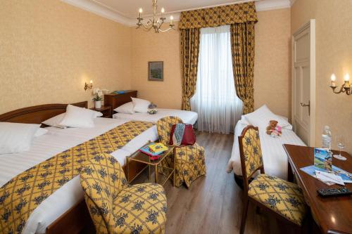 Postel nebo postele na pokoji v ubytování International au Lac Historic Lakeside Hotel