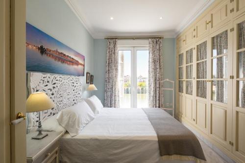 1 dormitorio con cama y ventana grande en Veoapartment Betis Triana, en Sevilla