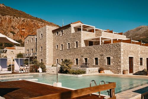 a building with a swimming pool in front of a building at Itilo Traditional Hotel in Neo Itilo