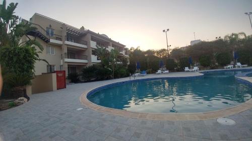 a large swimming pool in front of a building at Pyla Gardens A202 Studio in Pyla