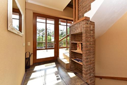 a living room with a brick fireplace and a window at Spa Villa Trakai in Trakai
