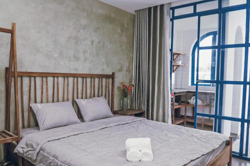 a bedroom with a bed with two towels on it at Ivy house in Hue