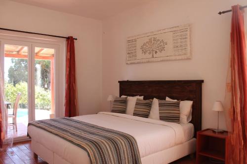 een slaapkamer met een bed en een glazen schuifdeur bij Villa Alegria in Lagos