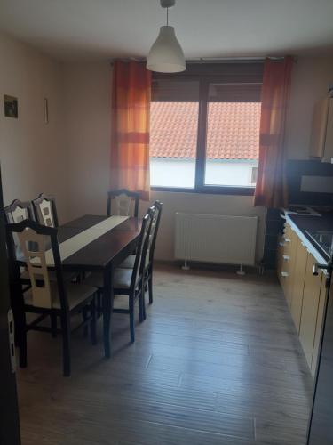 uma cozinha com mesa e cadeiras num quarto em Nice apartment with terrace and like view . em Pogradec