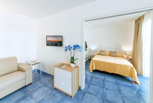 een slaapkamer met een bed en een bank bij Family Spa Hotel Le Canne in Ischia