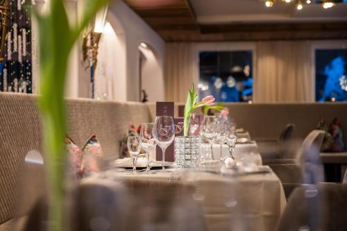 a table with glasses and plates on it in a restaurant at Wohlfühlhotel Innertalerhof in Gerlos