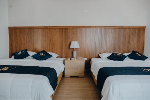 a hotel room with two beds with blue pillows at Paris Hotel Bình Thuận in Tuy Phong