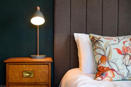 a bed with a pillow and a lamp on a nightstand at Kew Gardens Hotel in Kew