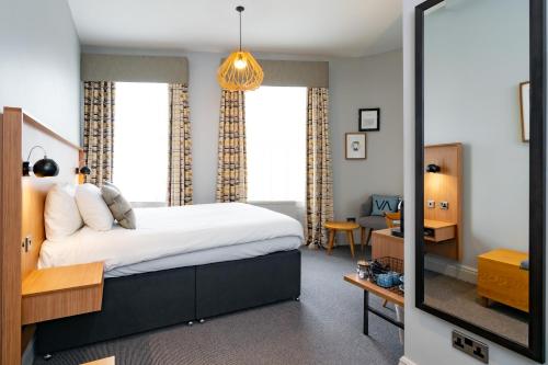 a bedroom with a large bed and a mirror at Victoria Inn in London