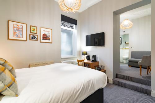 a bedroom with a bed and a living room at Victoria Inn in London