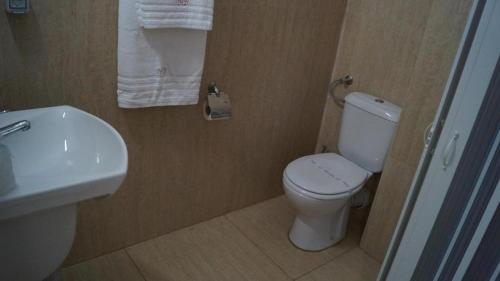 a bathroom with a white toilet and a sink at HOTEL BOURBON Vama Veche in Vama Veche