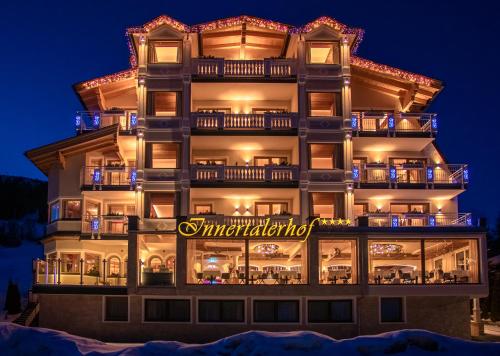 a tall building with a sign on it at night at Wohlfühlhotel Innertalerhof in Gerlos