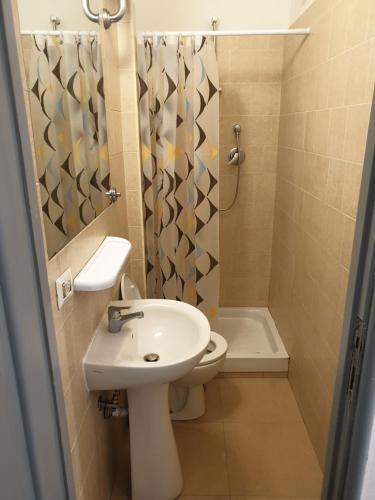 een badkamer met een wastafel, een toilet en een douche bij Art in Accommodation in Rome