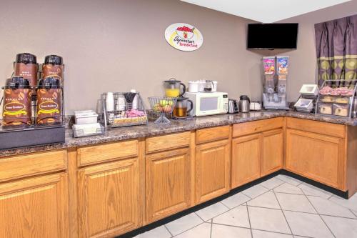 a kitchen with a counter with a microwave at Super 8 Grand Rapids City Center in Wyoming