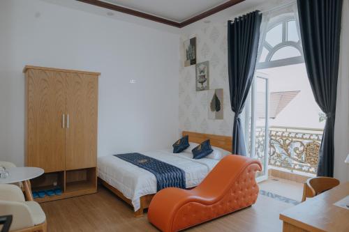 a bedroom with a bed and a chair and a window at Paris Hotel Bình Thuận in Tuy Phong