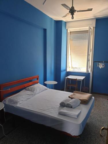 een blauwe slaapkamer met een bed met handdoeken erop bij Art in Accommodation in Rome