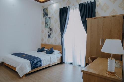a bedroom with a bed and a table with a lamp at Paris Hotel Bình Thuận in Tuy Phong