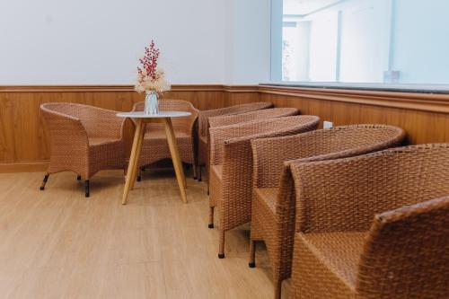 a row of chairs and a table with a vase of flowers at Paris Hotel Bình Thuận in Tuy Phong