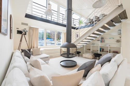 a living room with a white couch and a staircase at Charming houseboat featuring a sauna in London