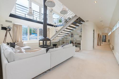 a living room with white furniture and a staircase at Charming houseboat featuring a sauna in London