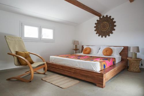 a bedroom with a bed and a chair at VILLA ZAIMA CON PISCINA PRIVATA in Santa Maria del Focallo