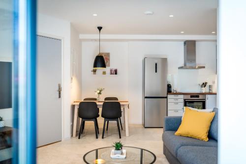 a living room with a blue couch and a kitchen at Luxury apartments Azalea Šibenik in Šibenik