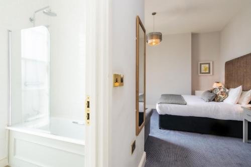 a bedroom with a bed and a tub in a room at Tulse Hill Hotel in London