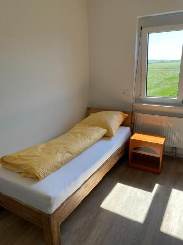 a small bedroom with a bed and a window at SITE.INN Wien in Himberg