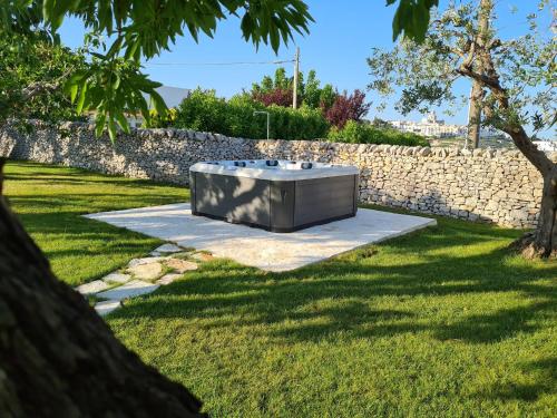 a hot tub in a yard next to a stone wall at Trulli Nannì in Locorotondo
