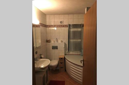 a bathroom with a tub and a toilet and a sink at Die Panorama-Wohnung-im-Grünem in Allensbach