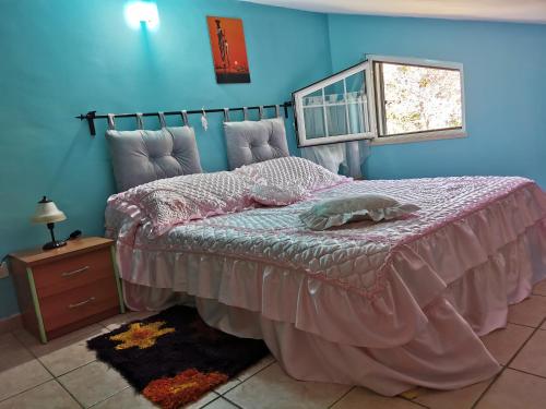 een slaapkamer met een bed met een roze dekbed en een raam bij Alloggio turistico Id 14737 La mansarda Free Parking, wi-fi in Rocca di Papa