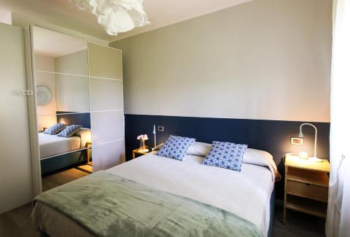 a bedroom with a bed with blue pillows on it at Maison Olive in Desenzano del Garda