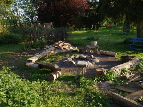a garden with a fire pit and a bench at Dom na Wzgórzu in Skolity