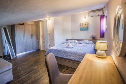 una camera da letto con un letto e un tavolo con una lampada di Rooftop Penthouse - Private Hottub & Duplex Whirlpool a Makarska
