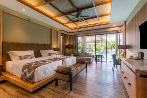 a bedroom with a bed and a living room at The Gantari Ubud Hotel & Villa in Ubud