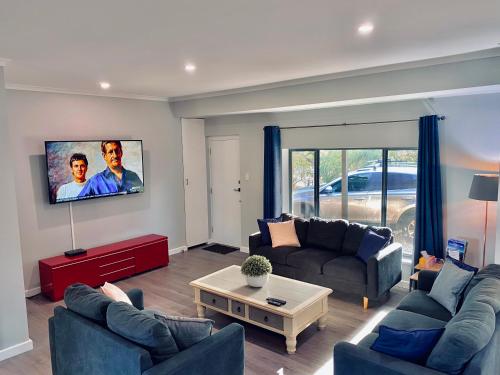 a living room with two couches and a tv at The Purple Door on Seaview in Victor Harbor