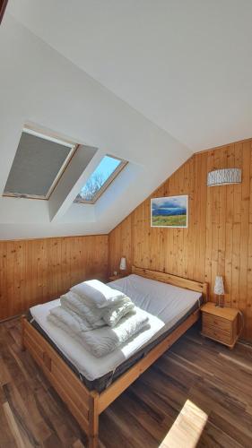 uma cama grande num quarto com paredes de madeira em Apartament Antałówka ! em Zakopane