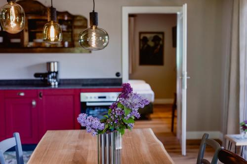 a vase of purple flowers on a table in a kitchen at Zur Nandl in St. Wolfgang