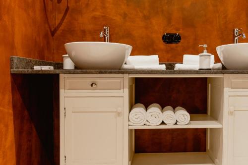 a bathroom with two sinks and towels on a counter at Zur Nandl in St. Wolfgang