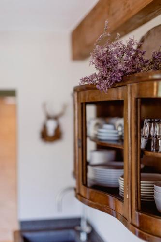 a wooden cabinet with plates and flowers in it at Zur Nandl in St. Wolfgang