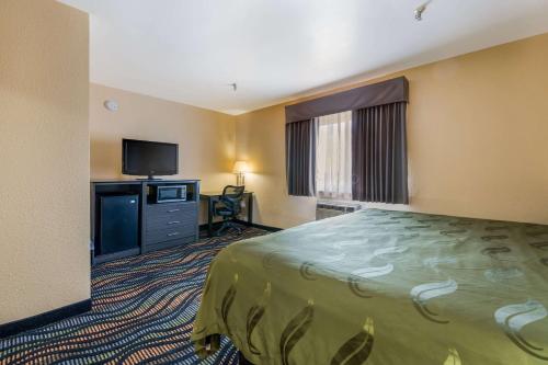 a hotel room with a bed and a flat screen tv at Equality Inn in Rockford
