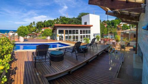 a deck with chairs next to a swimming pool at Cristal Pousada in Morro de São Paulo