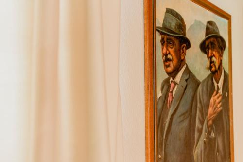 a painting of a man in a hat on a wall at Zur Nandl in St. Wolfgang
